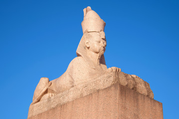 Ancient Egyptian Sphinx with University embankment close-up against a blue sky. Saint-Petersburg, Russia