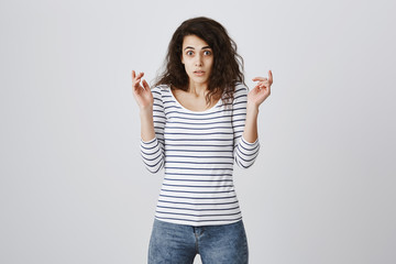 Anxious insecure daughter having problem. Portrait of confused and frustrated cute girlfriend raising hands and looking with popped eyes at camera, being shocked and worried over gray wall