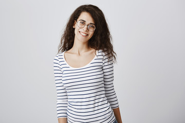 Obraz premium Happy to be in crowd of friends. Portrait of pleased charming curly-haired daughter in glasses smiling cheerfully, expressing friendly attitude while teaching children on part-time job