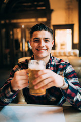 Young man with drink beer in a bar