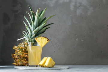 Pineapple fresh juice in glass on a wooden table