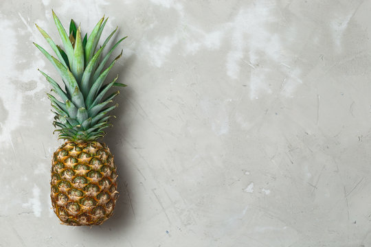 Whole pineapple fruit on grey concrete background