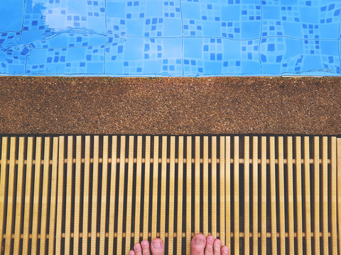 High Angle View of Barefoot Standing by the Swimming Pool