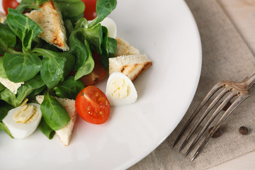 salad with quail egg, cherry tomato, crackers and corn salad on white background