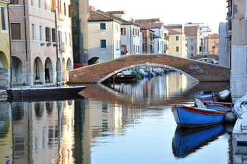 Fototapeta na wymiar Chioggia, Venice, Italy: canal in the old town with bridge and boats