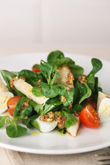 salad with quail egg, cherry tomato, crackers and corn salad on white background