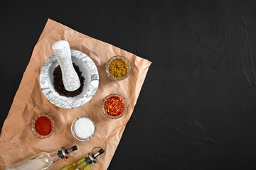 Various spices and mortar on black background with copy space