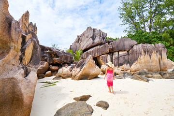 female tourist admires beautiful granite rocks on curieuse island, praslin, seychelles island