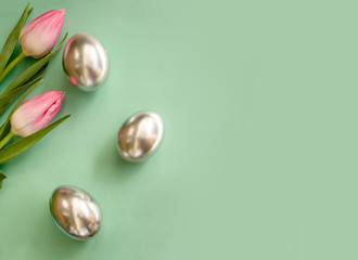 Tulips with silver eggs on pastel turquoise background, Easter