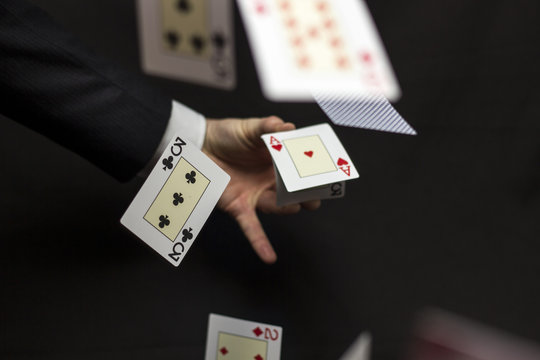 Flying playing cards with hand on a dark background