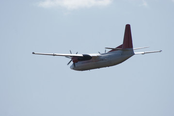 two-engined propeller airplane flying away