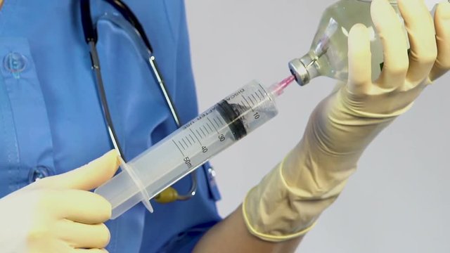 Veterinarian taking medicine in syringe, going to inject infected animal