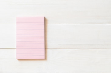 Naklejka premium One blank pastel sweet pink color reminder paper pad with horizontal line stripes on white pine wood