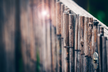 Textured fence made of thin wooden sticks aged and weathered. Natural background  of wooden rails in a vertical row.