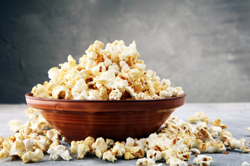 Salt popcorn or sweet popcorn on old grey background.