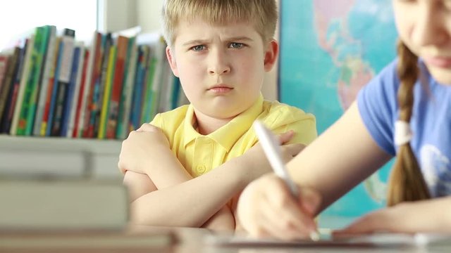 Dissatisfied, offended boy. A sad child in class.