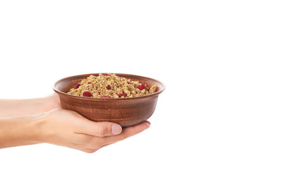 homemade granola with dried fruits in ceramic jar in hand isolated on white background. copy space, template