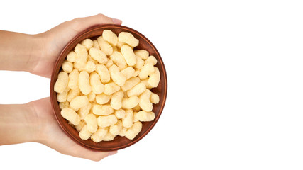 Light and delicious corn sticks in hand isolated on white background, healthy sweet snack. copy space, template