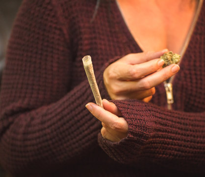 Woman Holding Cannabis Buds and Joint