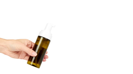 Plastic spray bottle with pump in hand isolated on white background. Foam dispenser for face care. Container with body lotion. copy space, template.