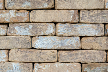 Wall of an old uneven brown brick. background