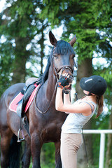 Obraz premium Teenage lady-equestrian checking her bay horse's teeth condition