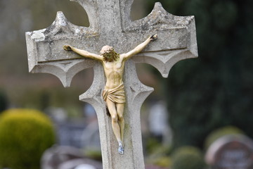 Weathered sculpture of Jesus Christ on a tombstone 