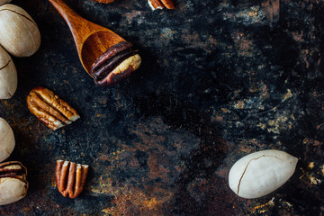 Pecan nut and wooden spoon on rustic table.