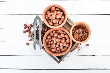 Set of hazelnuts in bowls. On a white wooden background. Top view. Copy space for your text.