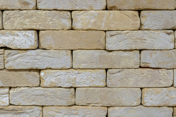 Wall of an old uneven light brick. background
