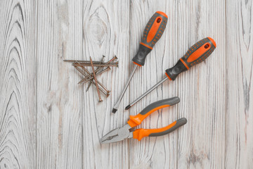 A set of tools on a wooden background.
Joiner tool.
Screws and screwdrivers on the table.
shelf with tool.
Plastic container for storing small parts.
Box for small parts storage.
