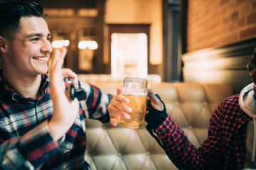 Do not drink and drive. Young guy is holding car keys and refusing to drink beer from his friend in...