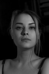 Naklejka premium Beautiful sensual blonde girl. Close-up of an attractive girl of European appearance on dark background.