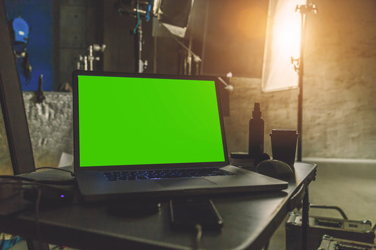 laptop with a green screen  on a table in production studio close up