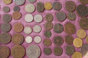 Old Soviet coins and Russian pre-revolutionary coins are laid out on a lilac background on a flea market. The inscription on the coins "penny".