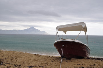 Small boat on the beach, Sithonia, Greece. In the background you can see Mount Áthos.