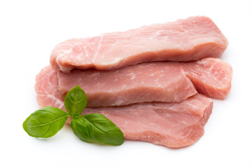 Fresh pork fillet with basil on a white background.