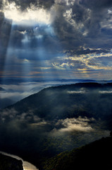 Light shining on cloud in valley