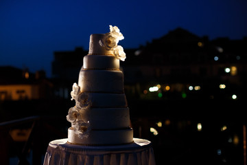 White wedding cake decorated with crystals and glaze bow