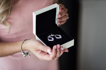 female hands holding a box of silver earrings