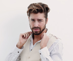 Obraz premium A man adjusts the collar of a white shirt