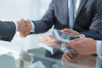 Two confident businessmen shaking hands during a meeting in the