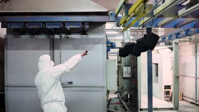 a man in a protective suit opens the gates to the oven and brings there the details
