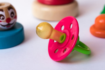 Children's pacifier with a colored wooden pyramid clown