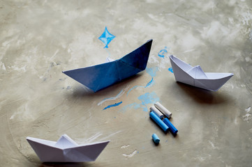 Dreams about the sea. A symbol of travel and freedom. A ship made of paper. Pastel crayons.