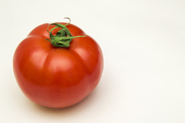 red tomato with green leaf on white background