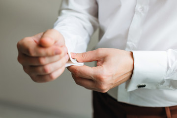 the groom who wears cufflinks on the cuffs of a white shirt