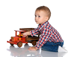Fototapeta premium A little boy is playing with a toy car.
