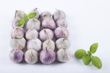 small garlics on white background with basil