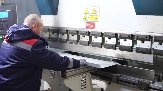 Operator working cut and bending metal sheet by high precision metal sheet bending machine, cnc control metal sheet bending machine in factory
